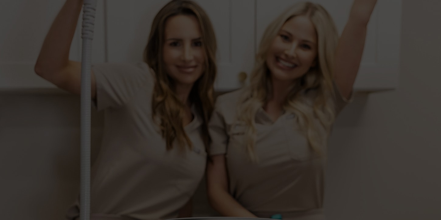 Two smiling professionals in a spa setting.