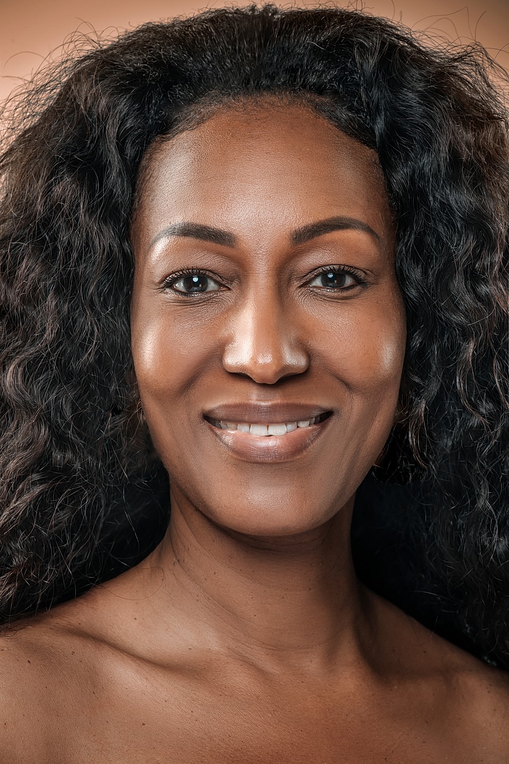 Smiling woman with curly hair and natural beauty.