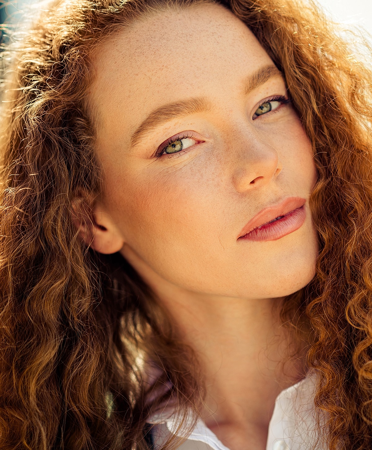 Close-up portrait of a woman with curly hair.
