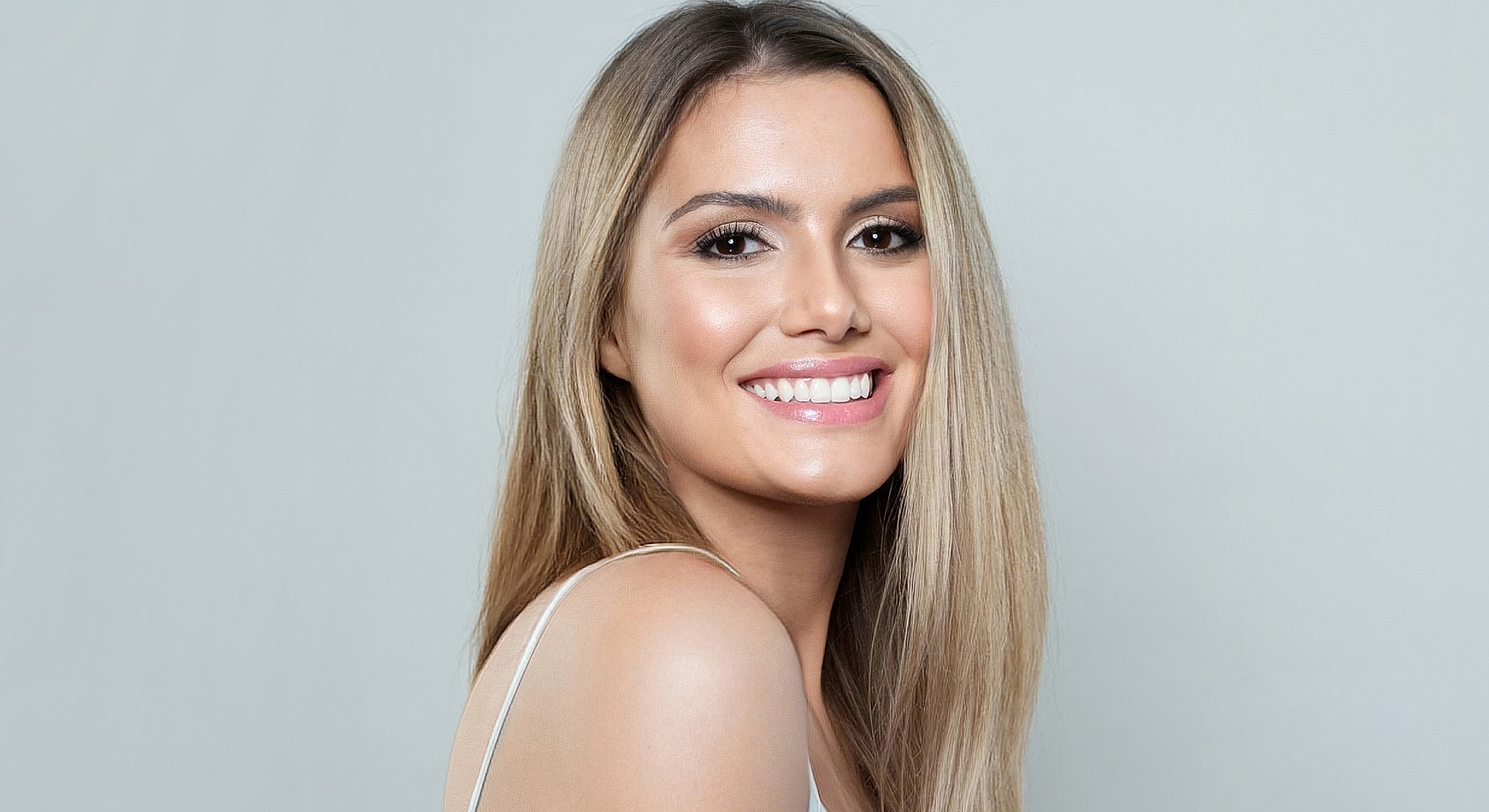 Smiling woman with long, straight blonde hair.